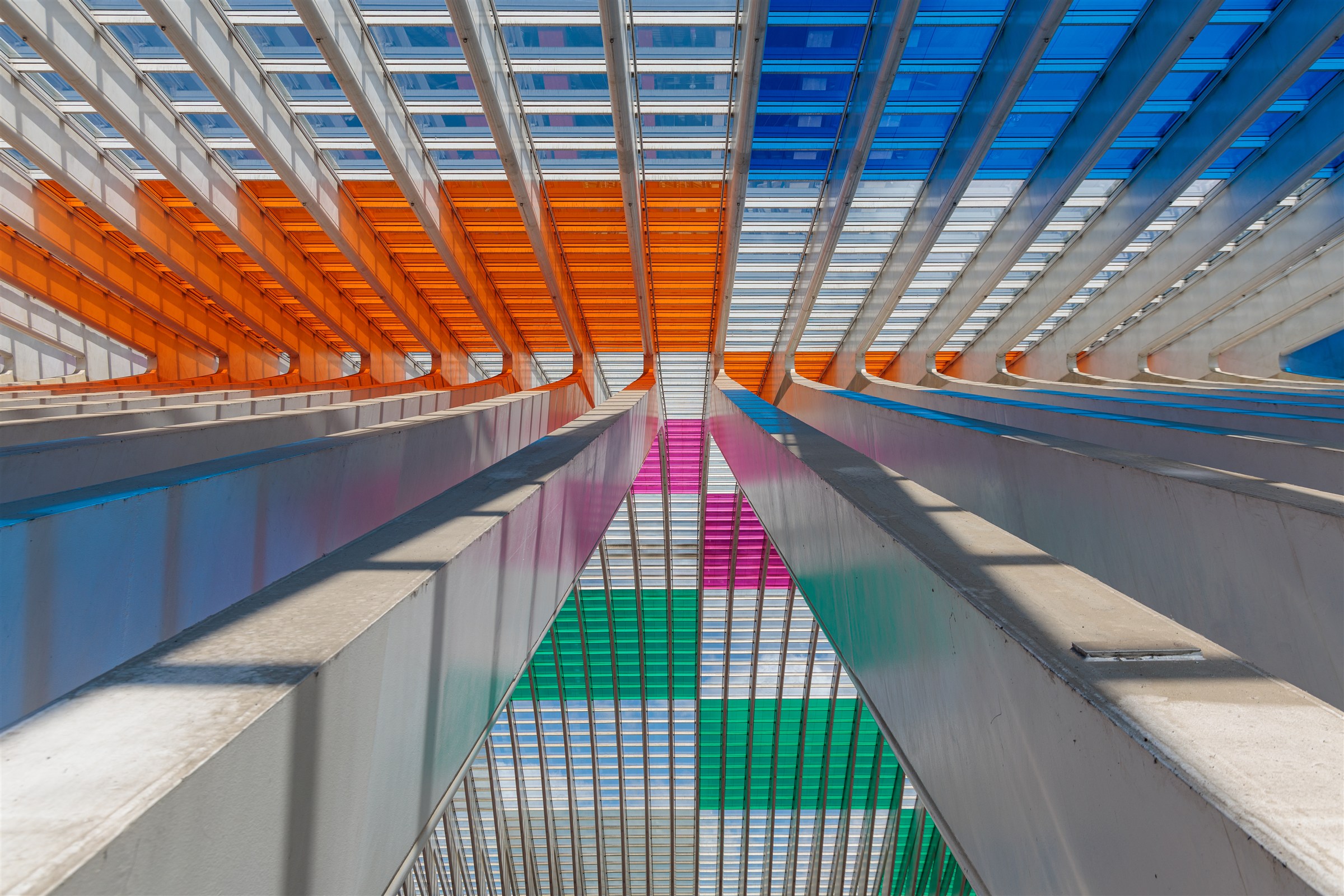 Symmetrische Architektur mit weißen Trägern und farbigen Glasflächen